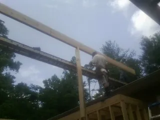 Carpenter setting a ridge beam over a new addition frame — Ice Dam Removal by Roofing Brothers in Wattsburg