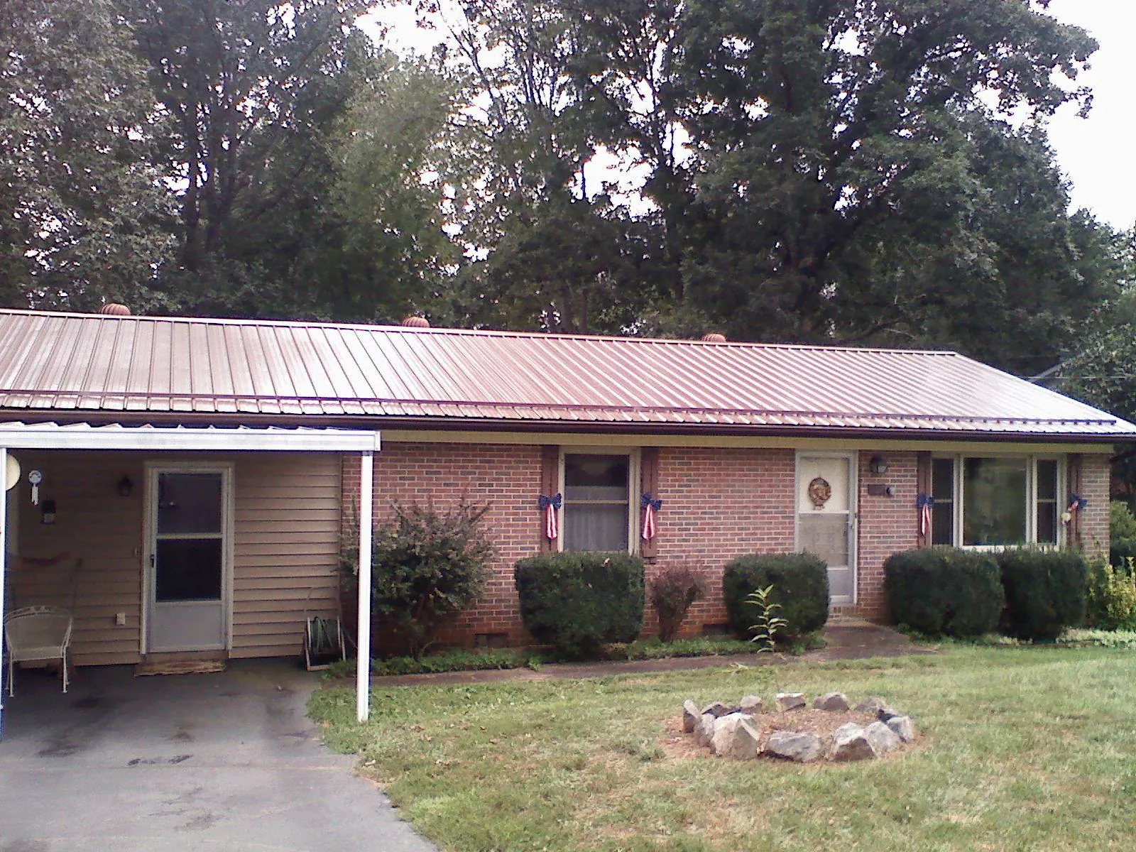 Bronze metal roof and carport on a brick ranch home — Roof Repair work by our crew in Wattsburg